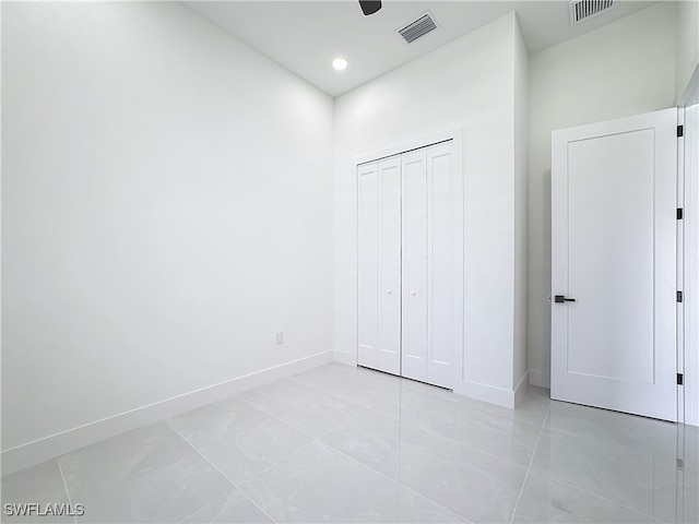 unfurnished bedroom featuring light tile patterned flooring, ceiling fan, and a closet