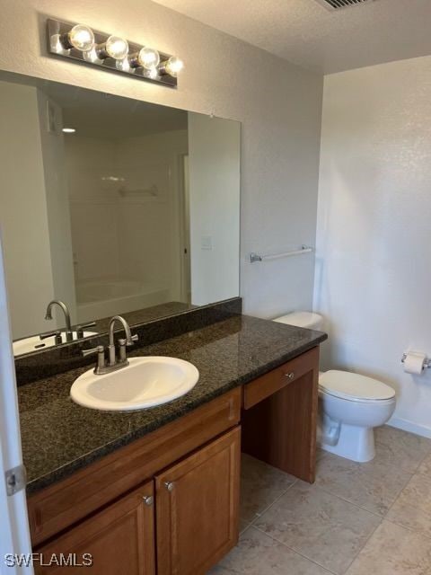 bathroom featuring vanity, tile patterned flooring, toilet, and walk in shower