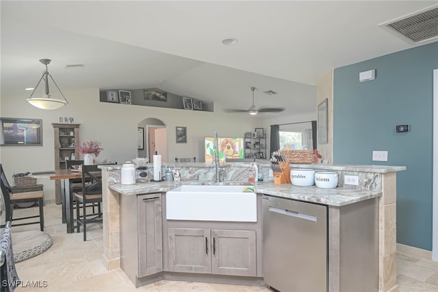 kitchen featuring vaulted ceiling, light stone counters, pendant lighting, ceiling fan, and stainless steel dishwasher