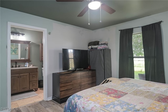 bedroom with ceiling fan, light hardwood / wood-style floors, and ensuite bathroom