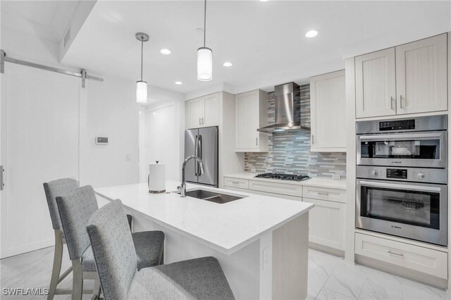 kitchen featuring stainless steel appliances, backsplash, light tile patterned floors, sink, and wall chimney range hood