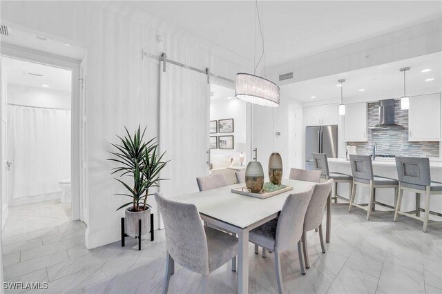 dining space with light tile patterned floors, sink, and a barn door