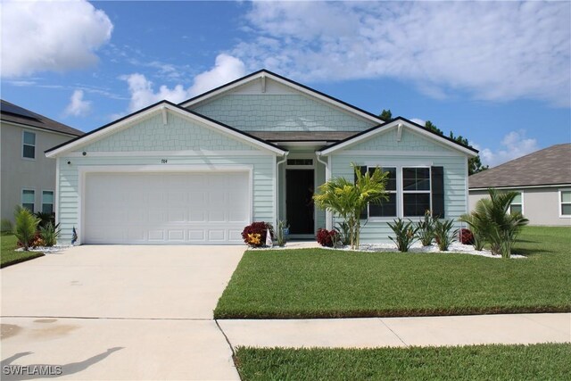 view of front of property featuring a front yard and a garage