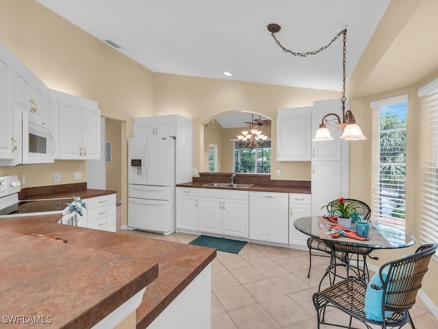 20141 Seagrove St Unit 308, Estero, FL 33928 - kitchen with white appliances, dark countertops, a sink, a chandelier, and plenty of natural light