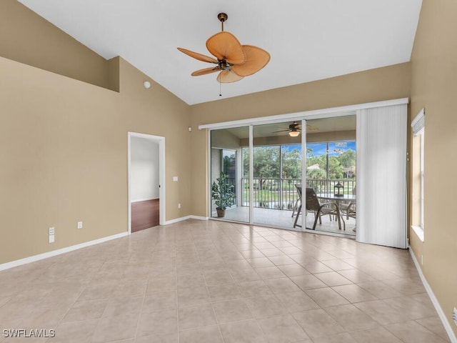 empty room featuring a towering ceiling, ceiling fan, and light tile patterned flooring