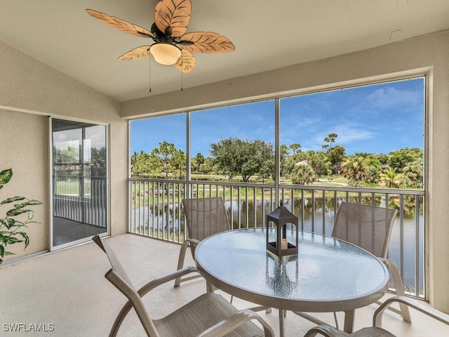 sunroom featuring a water view, vaulted ceiling, and ceiling fan