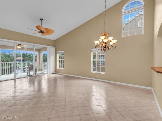 tiled empty room with a water view, a healthy amount of sunlight, a towering ceiling, and a chandelier