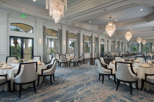 dining space with a notable chandelier, ornamental molding, and french doors