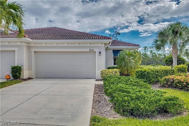9241 Aviano Dr, Fort Myers, FL 33913 - mediterranean / spanish home with a tiled roof, stucco siding, driveway, and a garage