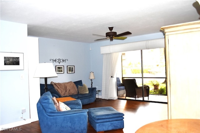 living room with dark wood-type flooring and ceiling fan