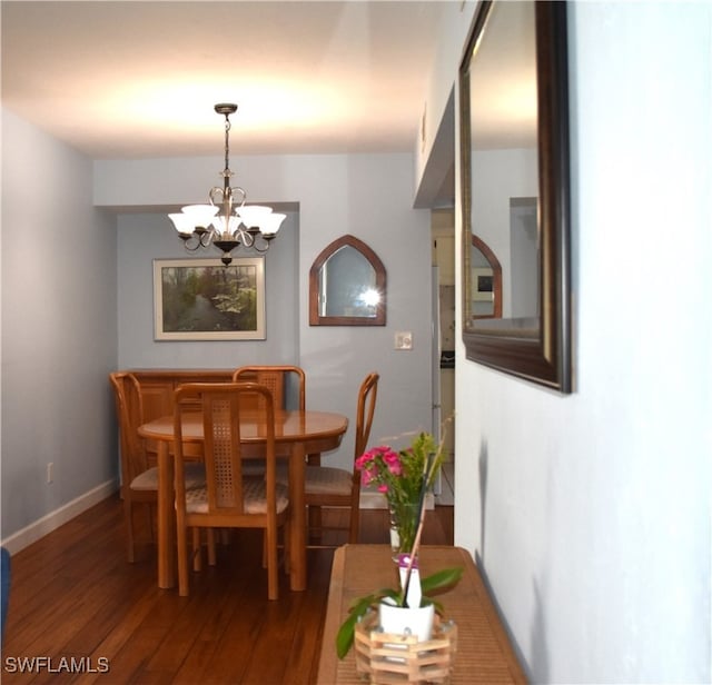 dining room featuring an inviting chandelier and dark hardwood / wood-style flooring