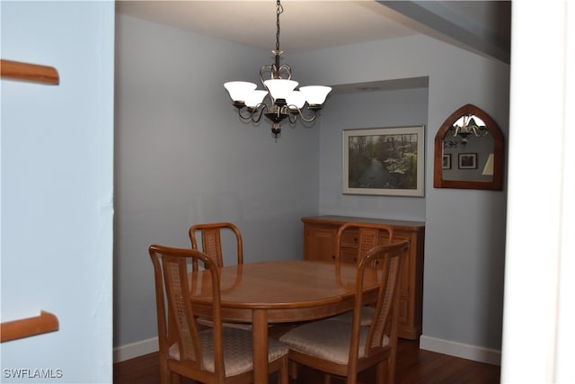 dining area featuring dark wood-type flooring and a chandelier