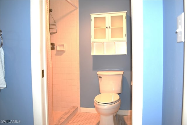 bathroom with tiled shower, tile patterned floors, and toilet