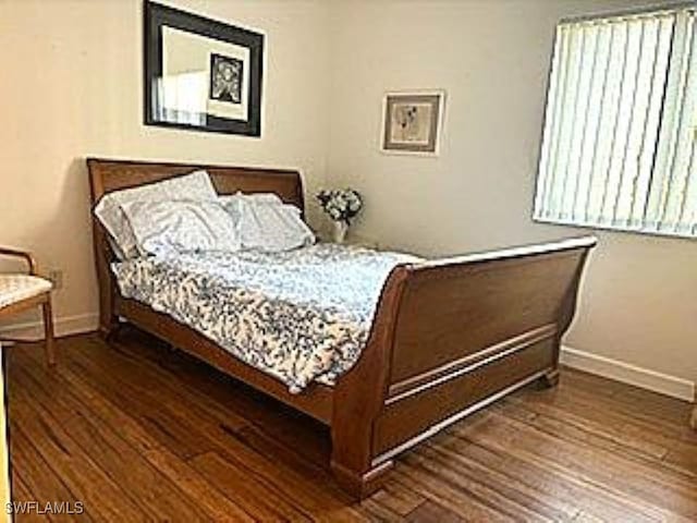 bedroom with dark hardwood / wood-style flooring