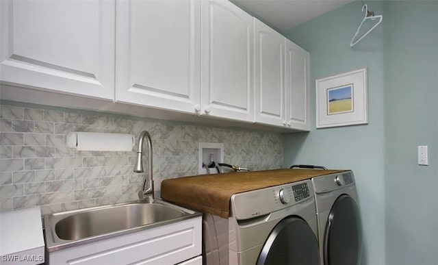 laundry area featuring washing machine and clothes dryer, a sink, and cabinet space