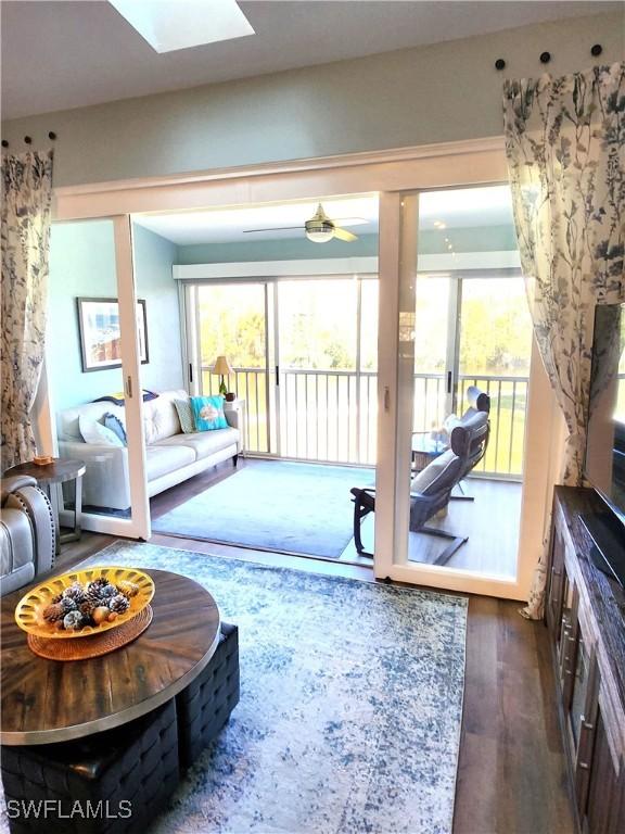 living room with a skylight and dark wood-style flooring