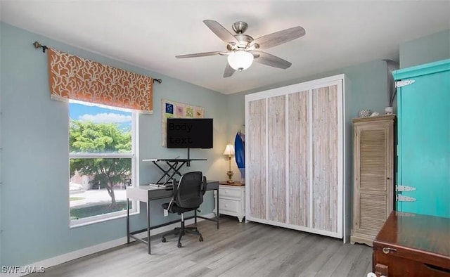 home office featuring wood finished floors, a ceiling fan, and baseboards