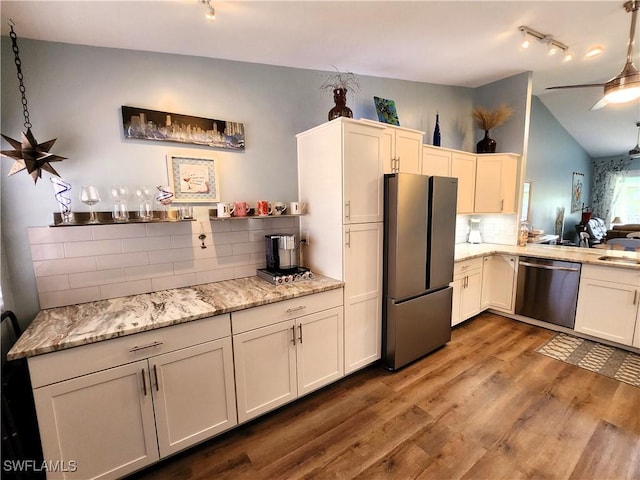 kitchen with ceiling fan, wood finished floors, hanging light fixtures, appliances with stainless steel finishes, and backsplash