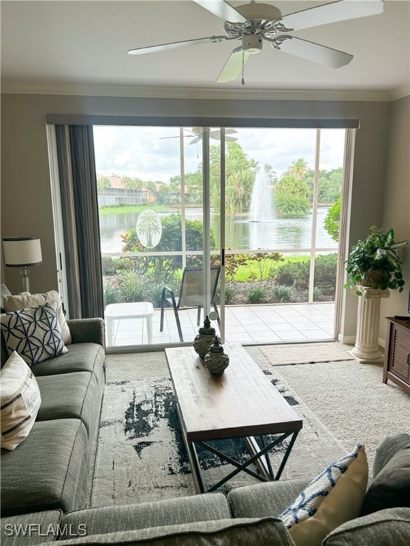 carpeted living room with ceiling fan, a water view, and ornamental molding