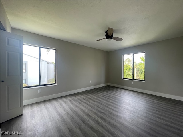 empty room with a healthy amount of sunlight, hardwood / wood-style floors, and ceiling fan