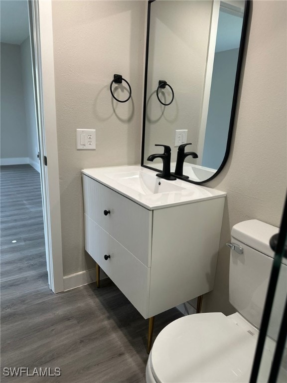 bathroom featuring vanity, toilet, and hardwood / wood-style flooring