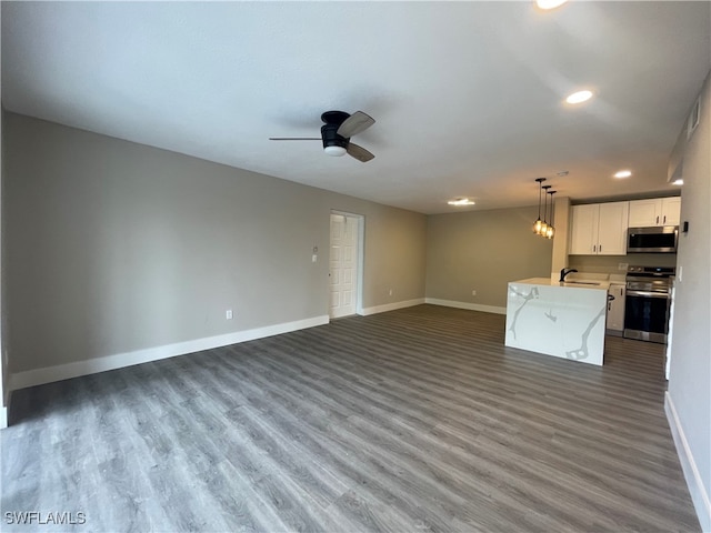 unfurnished living room featuring sink, ceiling fan, and hardwood / wood-style floors