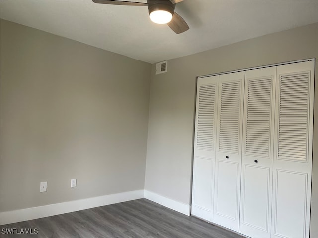 unfurnished bedroom with ceiling fan, wood-type flooring, and a closet