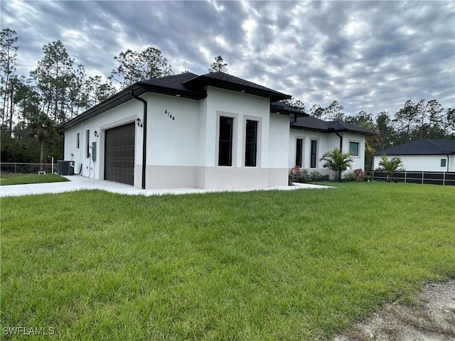 view of home's exterior featuring cooling unit, a garage, and a lawn