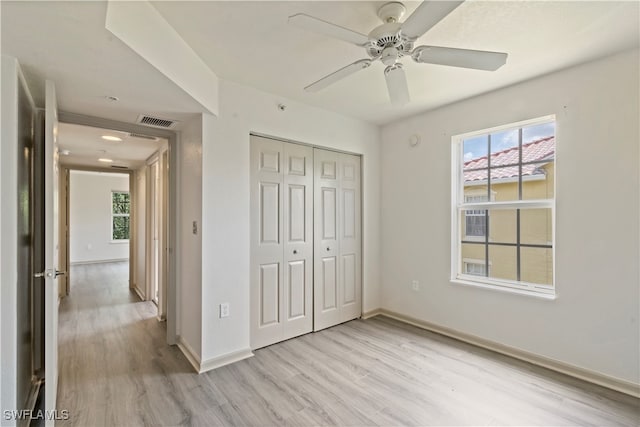 unfurnished bedroom featuring a closet, ceiling fan, and light wood-type flooring