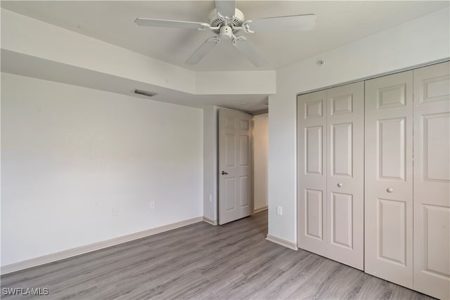 unfurnished bedroom with a closet, ceiling fan, and light wood-type flooring