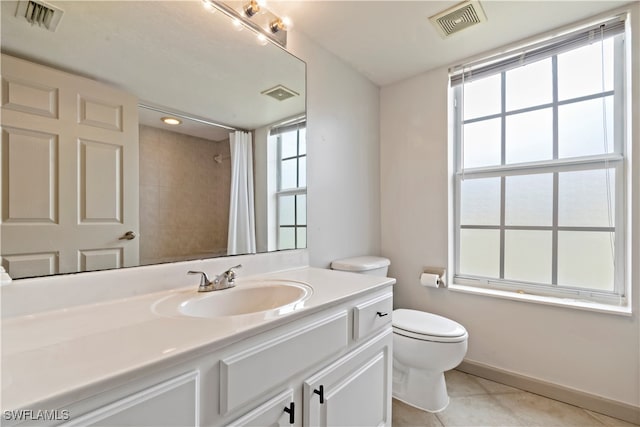 bathroom featuring tile patterned flooring, toilet, and vanity