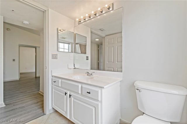 bathroom with hardwood / wood-style floors, toilet, and vanity