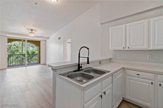 kitchen featuring white cabinets, vaulted ceiling, sink, kitchen peninsula, and dishwasher