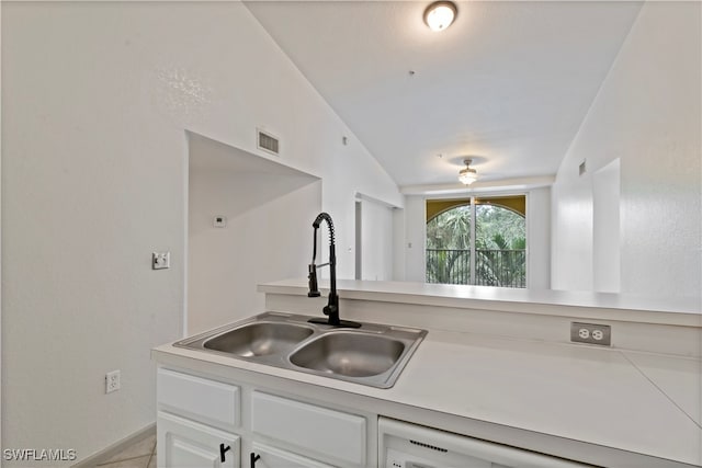 kitchen featuring white cabinets, lofted ceiling, dishwashing machine, and sink