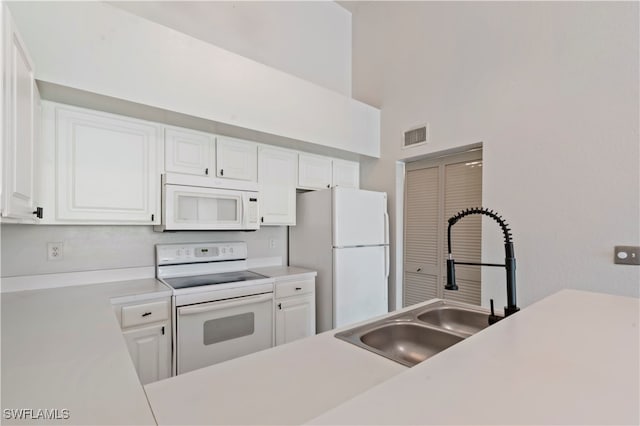 kitchen with sink, white cabinets, and white appliances