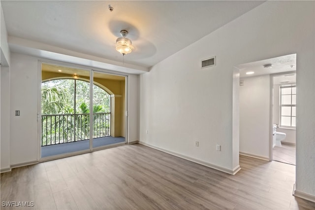 unfurnished room with lofted ceiling, a healthy amount of sunlight, hardwood / wood-style floors, and ceiling fan