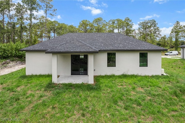 rear view of property with a lawn