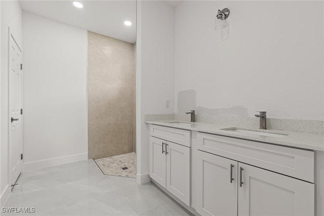 bathroom featuring a tile shower, tile patterned flooring, and vanity