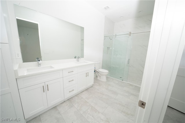 bathroom featuring vanity, toilet, and a shower with shower door