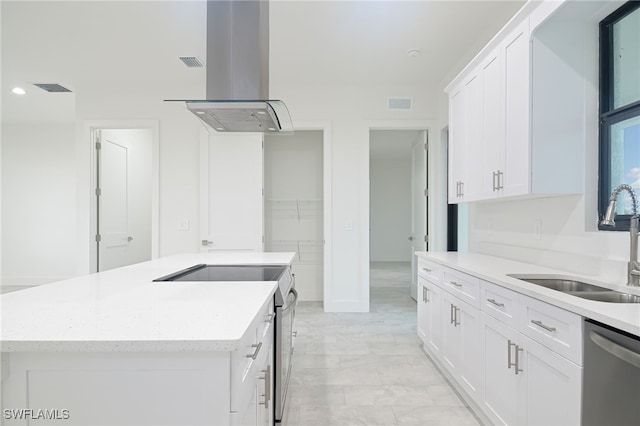 kitchen with white cabinets, stainless steel appliances, a kitchen island, and wall chimney exhaust hood