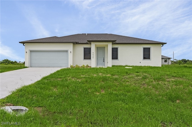 view of front of home featuring a garage, a front yard, and driveway