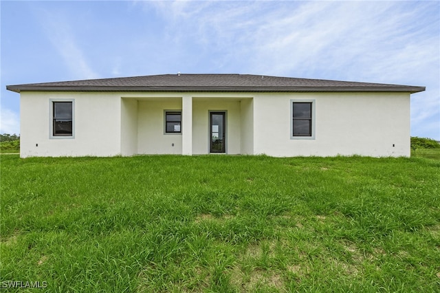 rear view of property with a lawn