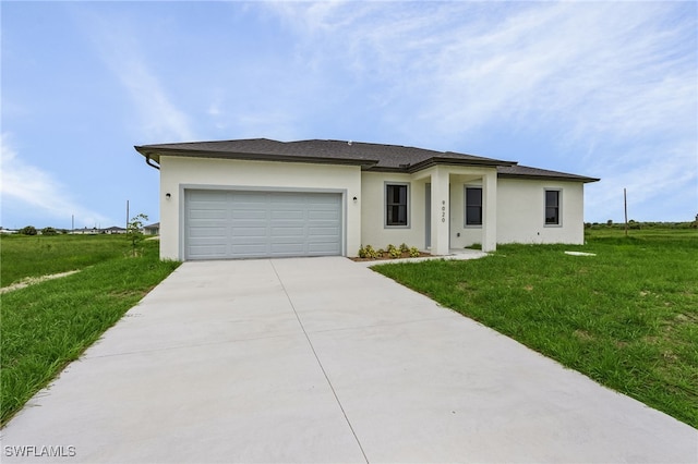 prairie-style house featuring a front yard, driveway, an attached garage, and stucco siding