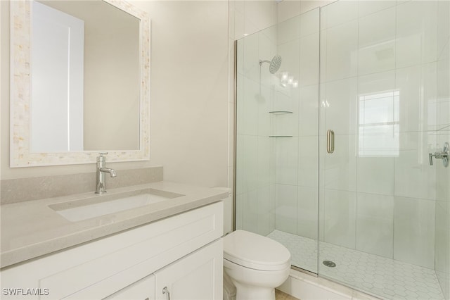 bathroom with vanity, a shower with shower door, and toilet