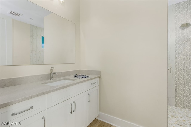 bathroom featuring vanity and tiled shower