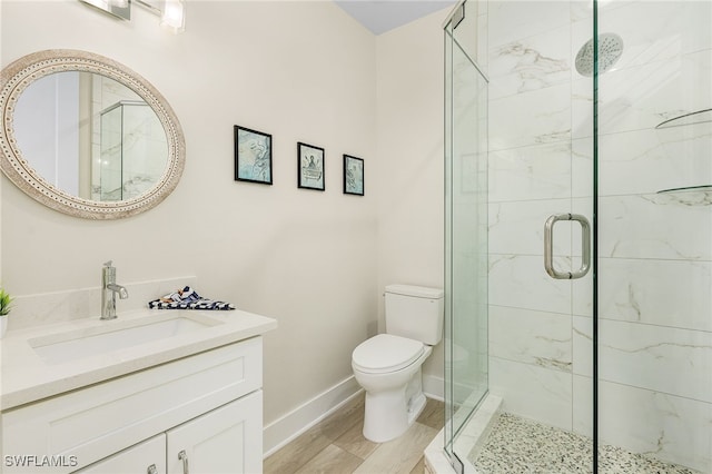 bathroom with toilet, wood-type flooring, vanity, and walk in shower