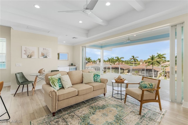 living room with beamed ceiling, ceiling fan, ornamental molding, and light hardwood / wood-style floors