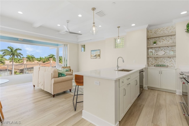 kitchen with dishwasher, white cabinetry, sink, hanging light fixtures, and light wood-type flooring