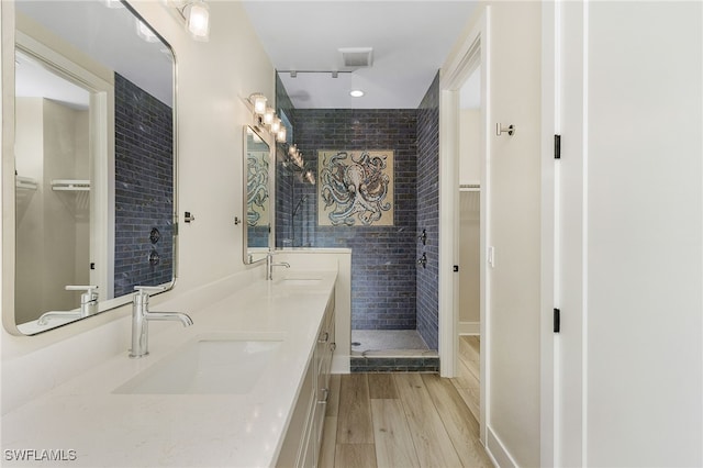 bathroom featuring tiled shower, vanity, and hardwood / wood-style floors