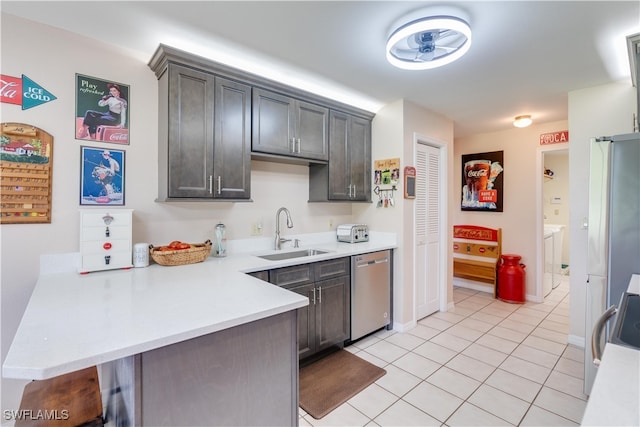 kitchen with kitchen peninsula, sink, light tile patterned flooring, dark brown cabinetry, and stainless steel dishwasher